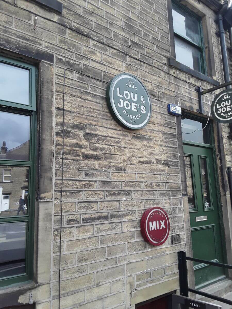 The sandstone brick building with the Lou & Joes Burger signage
