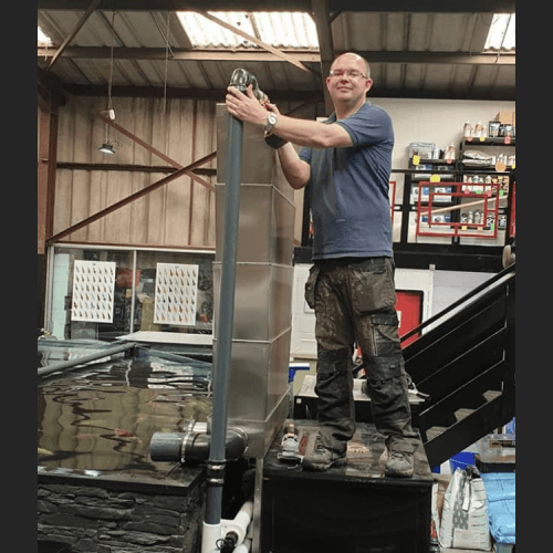 A bespoke bakki shower attached to a koi pond